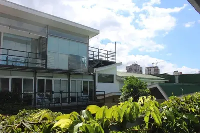 a building with a balcony and some plants at Cando Living Apartments in Central Avenue in San José