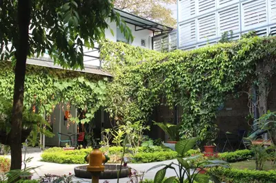an ivy covered building with a fountain in a garden at Cando Living Apartments in Central Avenue in San José