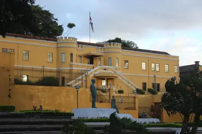 a yellow building with a statue in front of it at Cando Living Apartments in Central Avenue in San José