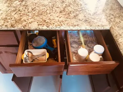 a kitchen counter with two wooden drawers with utensils at Las Pavitas Arenal Suites in Fortuna