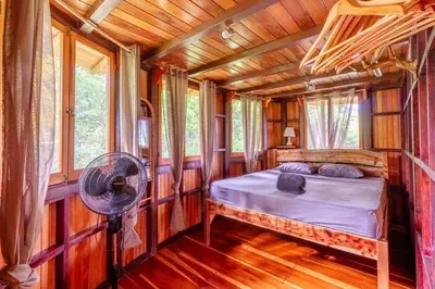 a bedroom in a tree house with a bed and a fan at Junglebungalow in Platanillo