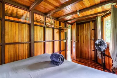 a bedroom with a bed in a room with wooden walls at Junglebungalow in Platanillo