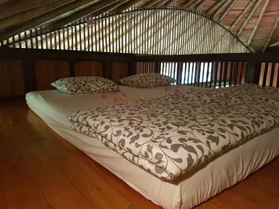 a large bed in a room with a wooden floor at Junglebungalow in Platanillo