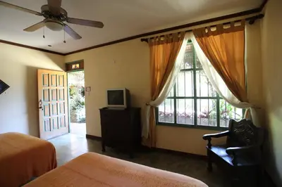 a bedroom with a bed and a tv and a window at Tierra Magica B&B and Art Studio in San José