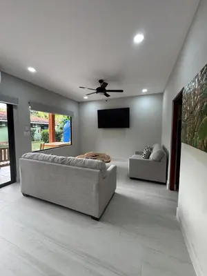 a living room with a couch and a flat screen tv at Bahia Esmeralda Boutique Hotel & Villas in Potrero