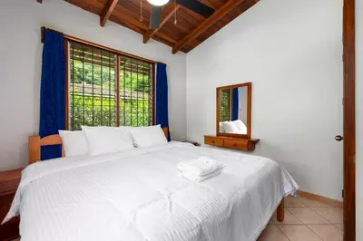 a bedroom with a large white bed and a window at Bahia Esmeralda Boutique Hotel & Villas in Potrero