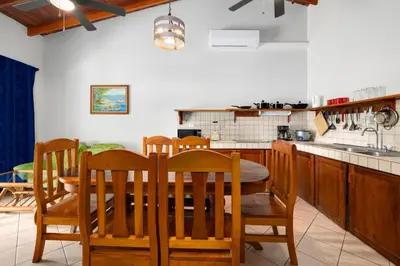 a kitchen with a table and chairs and a sink at Bahia Esmeralda Boutique Hotel & Villas in Potrero