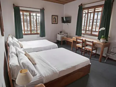 a bedroom with two beds and a desk with a computer at Fleur de Lys in San José