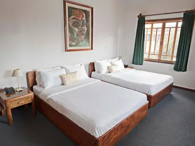 a bedroom with two beds and a picture of a clown at Fleur de Lys in San José
