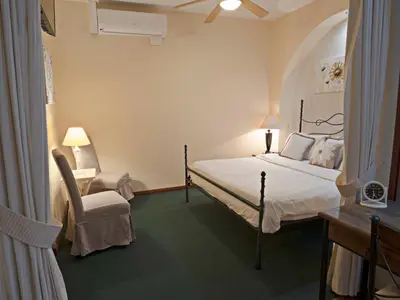 a bedroom with a bed and a chair and a desk at Fleur de Lys in San José