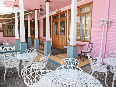 a pink building with tables and chairs on a patio at Fleur de Lys in San José