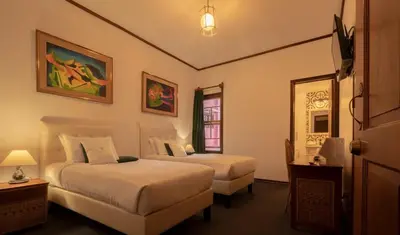 a hotel room with two beds and a window at Fleur de Lys in San José