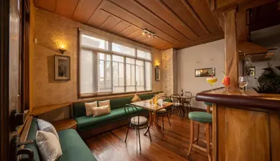 a bar with a green couch and a table in a room at Fleur de Lys in San José