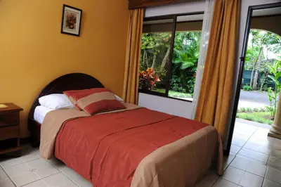 a bedroom with a bed and a large window at Hotel Robledal in Alajuela City