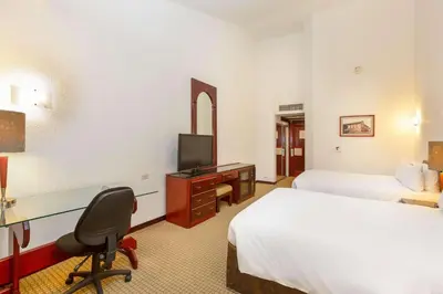 a hotel room with two beds and a desk with a television at Radisson San Jose-Costa Rica in San José