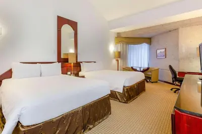 a hotel room with two beds and a desk at Radisson San Jose-Costa Rica in San José