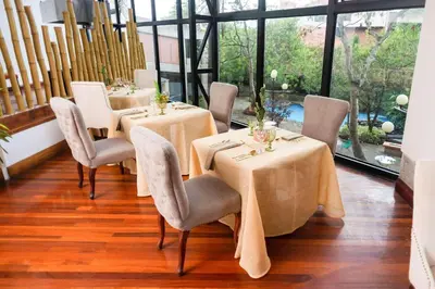 a dining room with tables and chairs and windows at Radisson San Jose-Costa Rica in San José