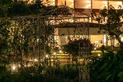 a garden at night with lights in a building at Hotel Bougainvillea San José in Santo Domingo