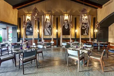 a restaurant with tables and chairs and portraits on the wall at Planet Hollywood Costa Rica by Royalton, An Autograph Collection All-Inclusive Resort in Papagayo, Guanacaste