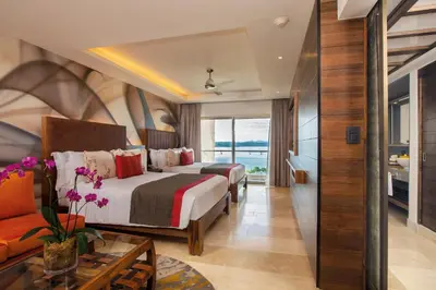 a hotel room with two beds and a couch at Planet Hollywood Costa Rica by Royalton, An Autograph Collection All-Inclusive Resort in Papagayo, Guanacaste