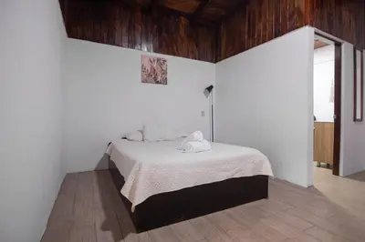 a bedroom with a bed with white sheets and towels at Hotel las Ardillas Monteverde in Monteverde Costa Rica
