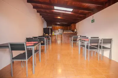 a dining room with tables and chairs and a kitchen at Hotel las Ardillas Monteverde in Monteverde Costa Rica