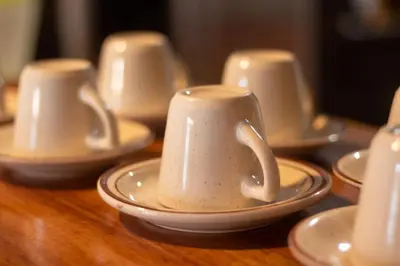 a group of white cups and saucers on a table at Hotel las Ardillas Monteverde in Monteverde Costa Rica