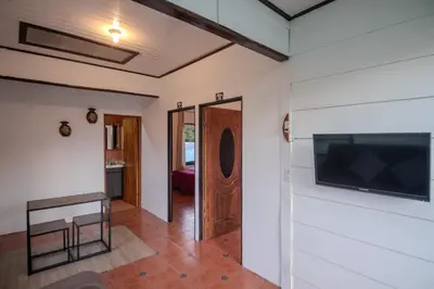 a hallway with a door and a tv on a wall at Hotel las Ardillas Monteverde in Monteverde Costa Rica
