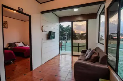 a living room with a couch and a view of a pool at Hotel las Ardillas Monteverde in Monteverde Costa Rica