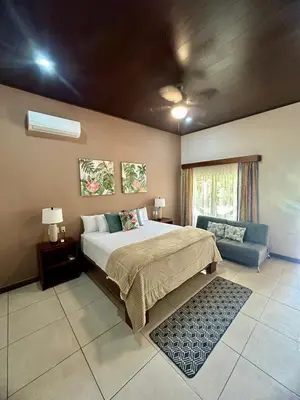 a bedroom with a large bed and a couch at Villa Tucan in Fortuna