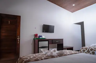 a bedroom with a bed and a tv on the wall at Villa Tucan in Fortuna