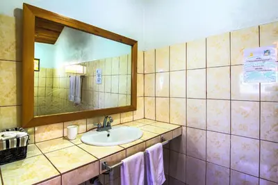 a bathroom with a sink and a mirror at Hotel Mango Valley in Grecia