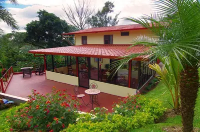 a house with a red roof and a patio at Hotel Mango Valley in Grecia