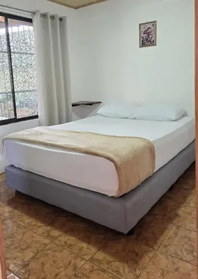 a bed in a bedroom with a large window at Casa Cattleya - Monteverde, Costa Rica in Monteverde Costa Rica