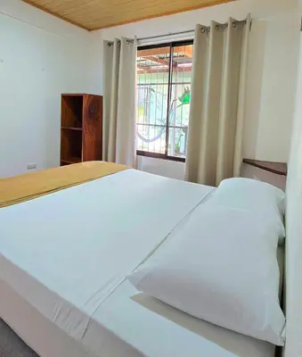 a bedroom with a large white bed with a window at Casa Cattleya - Monteverde, Costa Rica in Monteverde Costa Rica