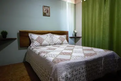 a bedroom with a bed and a green curtain at Casa Cattleya - Monteverde, Costa Rica in Monteverde Costa Rica