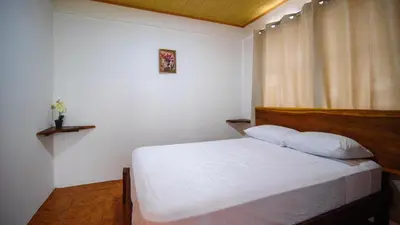 a bedroom with a white bed and a window at Casa Cattleya - Monteverde, Costa Rica in Monteverde Costa Rica
