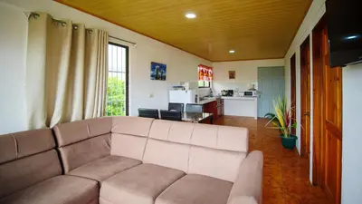 a living room with a couch and a kitchen at Casa Cattleya - Monteverde, Costa Rica in Monteverde Costa Rica