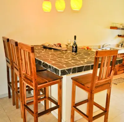 a kitchen with a table with chairs and a counter top at Costa Riki Apartments in Santa Teresa Beach