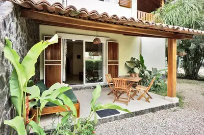 a patio of a house with a table and chairs at Costa Riki Apartments in Santa Teresa Beach