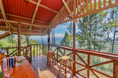 a room with a balcony with a table and chairs at Vista Turrialba Lodge in Turrialba