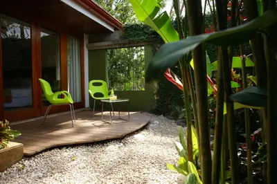 two green chairs and a table in a garden at Terrazas de Golf Boutique Hotel in San José