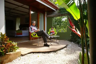 two people sitting in chairs on the porch of a house at Terrazas de Golf Boutique Hotel in San José
