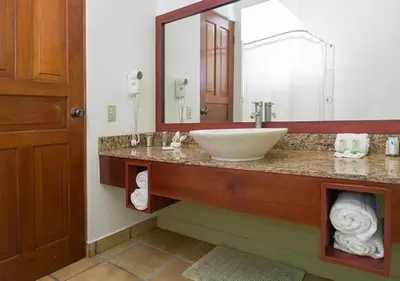 a bathroom with a sink and a large mirror at Terrazas de Golf Boutique Hotel in San José