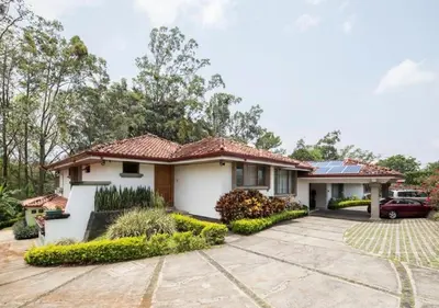 a house with a car parked in the driveway at Terrazas de Golf Boutique Hotel in San José