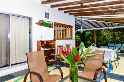 a dining room with a table and chairs and a vase with flowers at Casa Cedro - Portasol Vacation Rentals in Matapalo