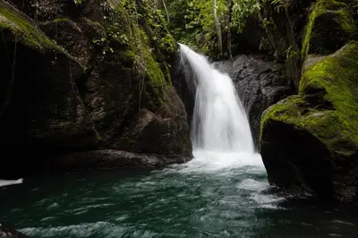 a waterfall in the middle of a river at Casa Cedro - Portasol Vacation Rentals in Matapalo
