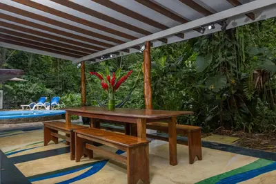 a table and benches under awning on a patio at Casa Cedro - Portasol Vacation Rentals in Matapalo