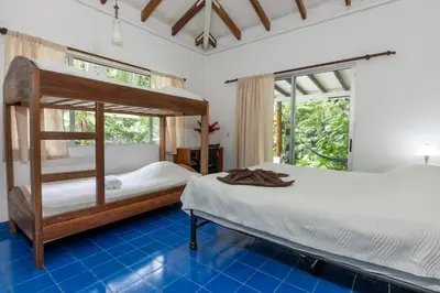 a bedroom with two bunk beds and blue tile floors at Casa Cedro - Portasol Vacation Rentals in Matapalo