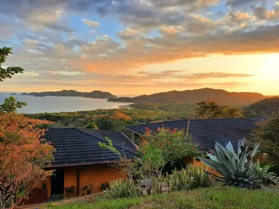 a view of a house with a lake in the background at Eco Boutique Hotel Vista Las Islas Reserva Natural in Paquera